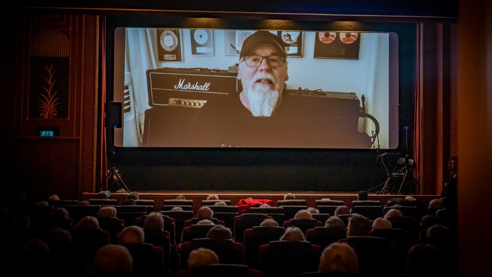 Lasse Andersson visas på bioduken i en inspelad video.