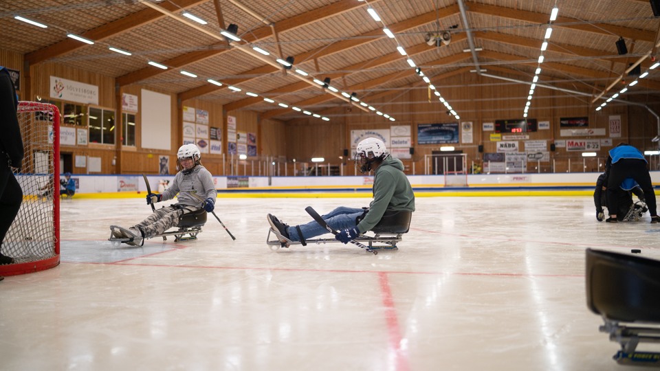 Ungdomar som sitter i hockeykälkar i Sölveshov, ishallen i Sölvesborg.