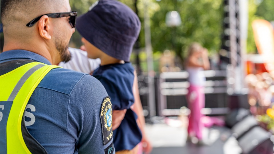 En polis håller ett barn intill Stortorgets scen.
