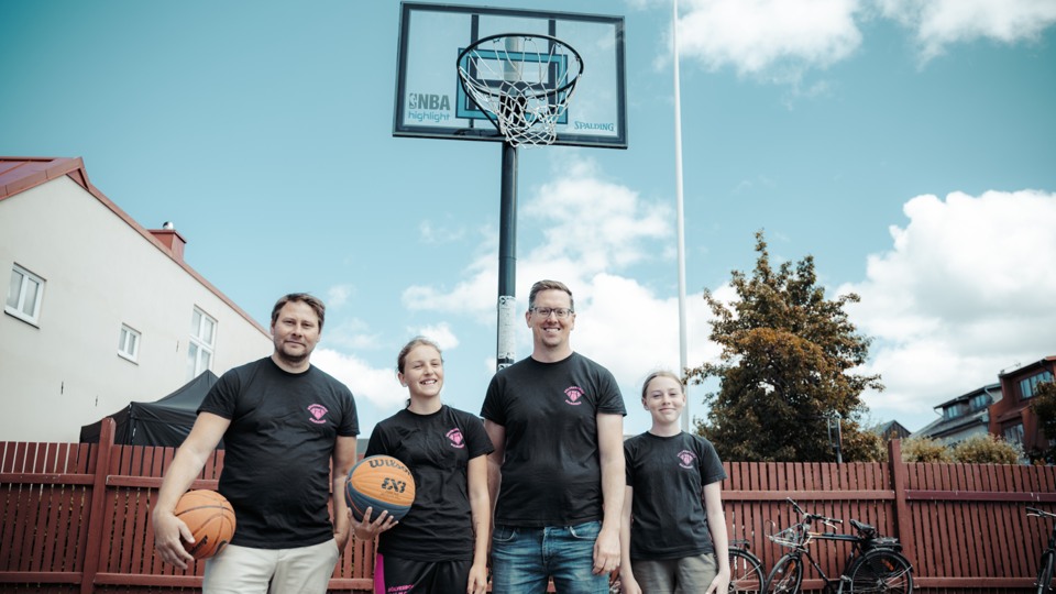 Fyra medlemmar i Sölvesborg basketförening står under en basketkorg.