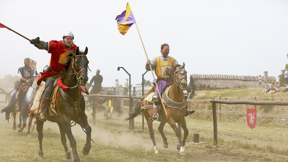 Riddare rider på sina hästar i medeltida utrustning.