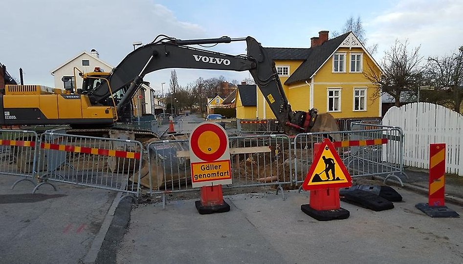 En grävmaskin gräver i en schaktgrop i en gata i Sölvesborg